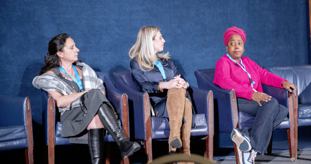 Esra Urkmez Uzel, Lilly Stairs, and Bikira Radcliffe speak on a panel about patient advocacy and cancer burnout prevention at the 2025 Cervical Cancer Summit. Bikira, wearing a bright pink shirt and matching head wrap, is seated on the left.