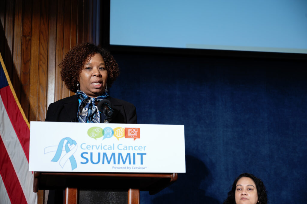 Dr. Lynn Richards McDonald, Clinical Program Director for cervical cancer screening at Johns Hopkins Hospital, speaks at the 2025 Cervical Cancer Summit, wearing a black suit jacket. The Summit logo is visible on the lectern as she addresses the audience through a microphone.